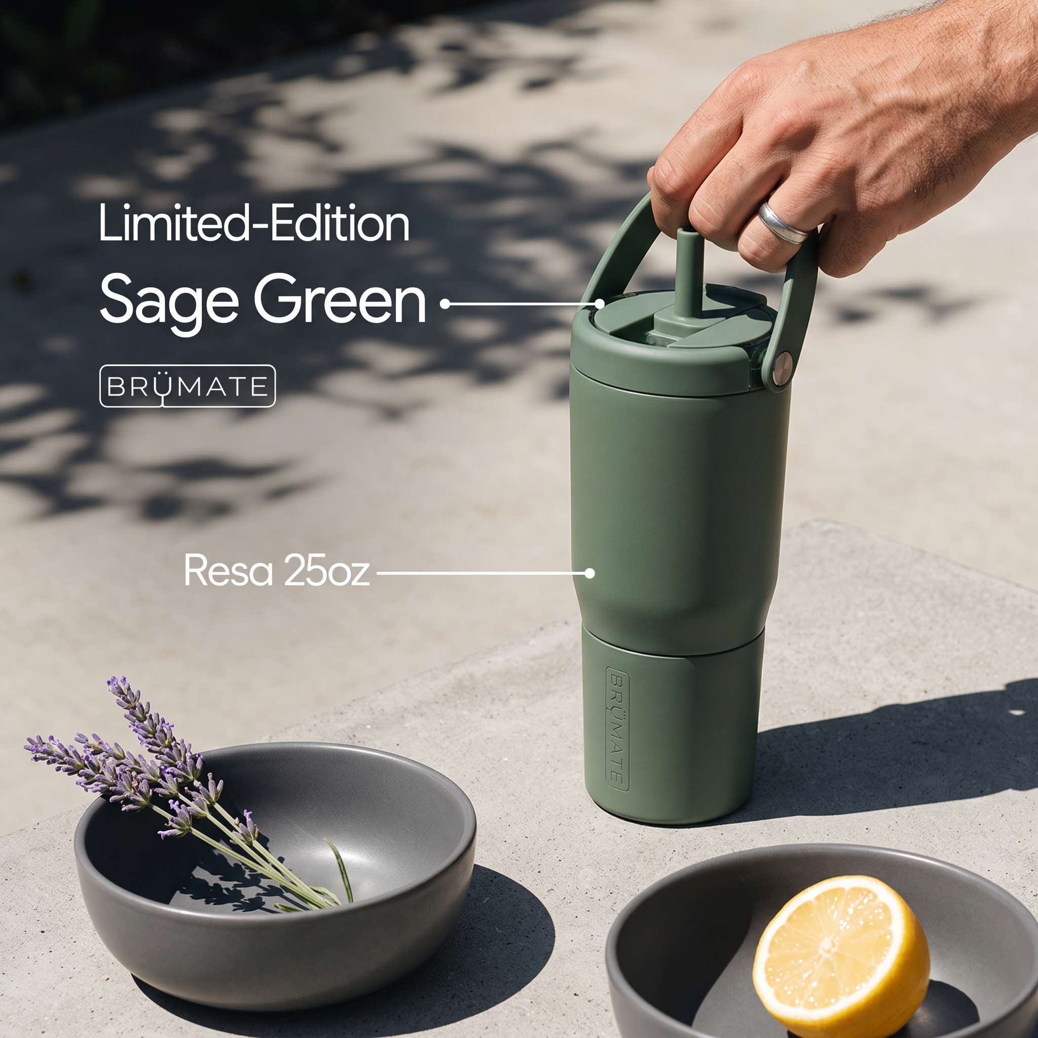 Hand lifting sage green insulated tumbler by its handle on sunny concrete, callout lines labelling Sage Green and Resa 25oz