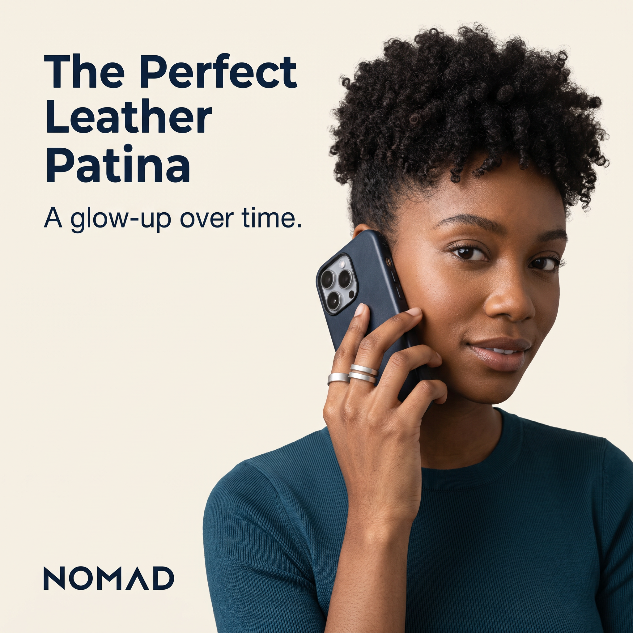 Woman with curly hair holding a navy leather phone case to her ear on cream background, headline The Perfect Leather Patina