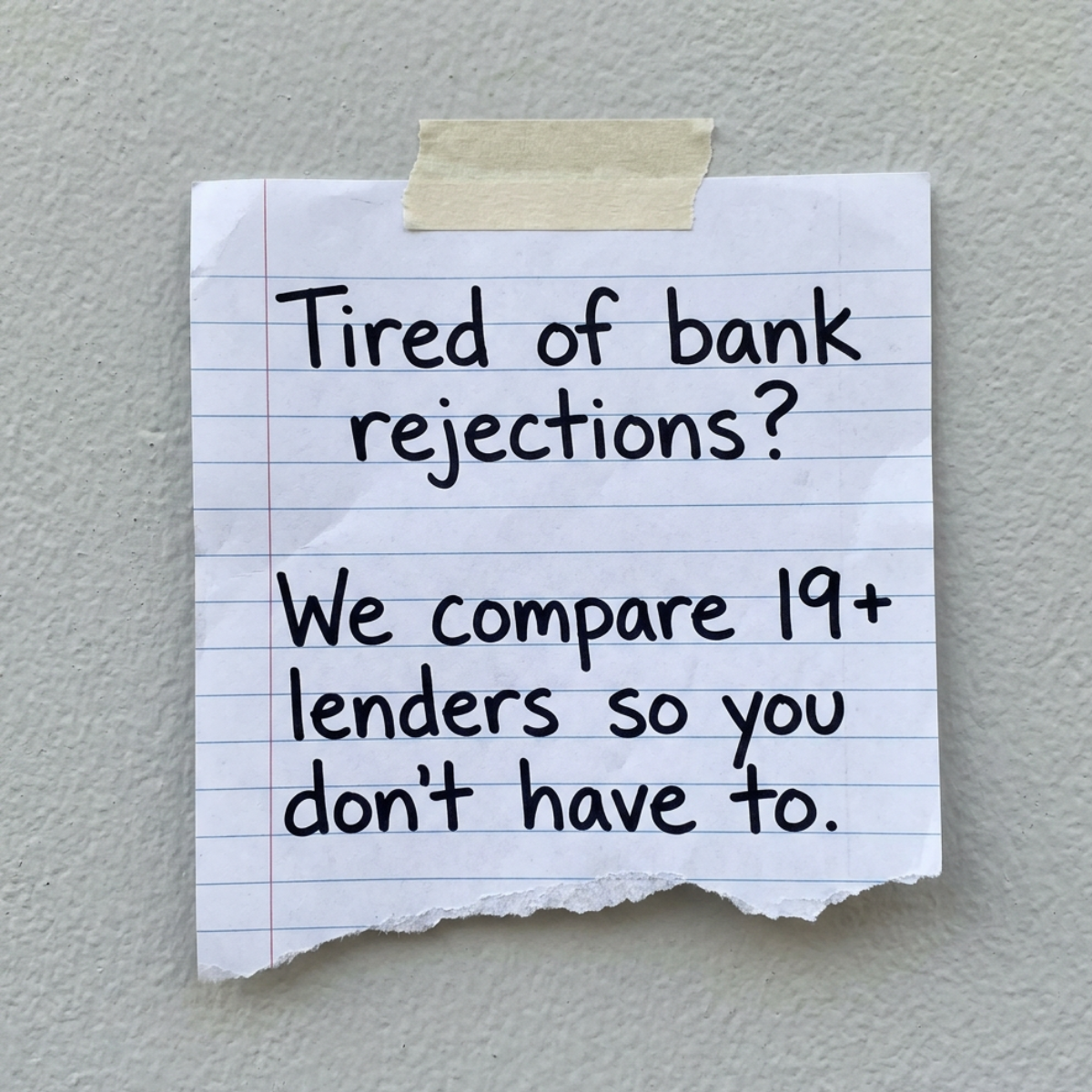 Torn lined notepad sheet taped to a grey wall: Tired of bank rejections? We compare 19+ lenders so you don't have to.
