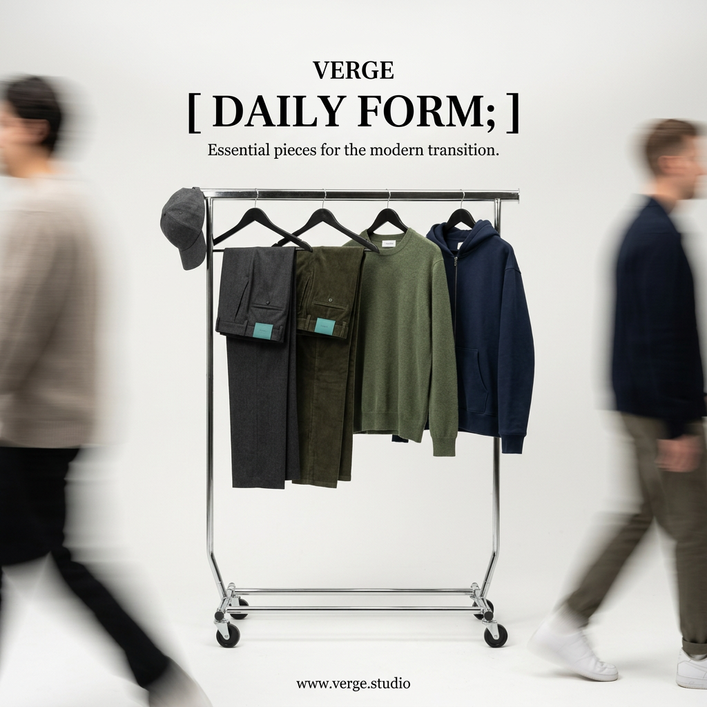 Chrome clothing rack holding grey and olive trousers, a green knit and a navy hoodie, with blurred people walking past