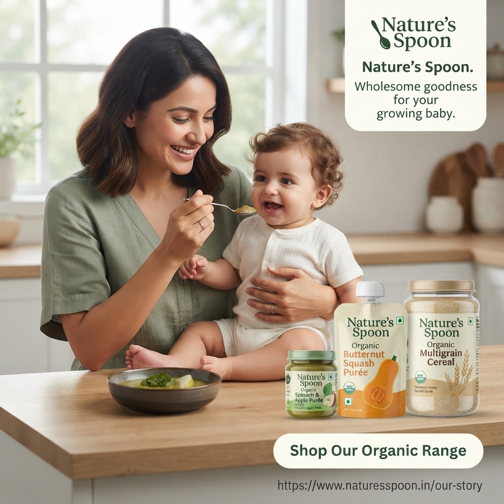 Smiling mother spoon-feeding a laughing baby on a kitchen counter beside Nature's Spoon organic purée jar, pouch and cereal