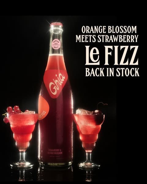 Ghia Le Fizz sparkling bottle between two red drinks with currants and cherry on black, with Back in Stock text