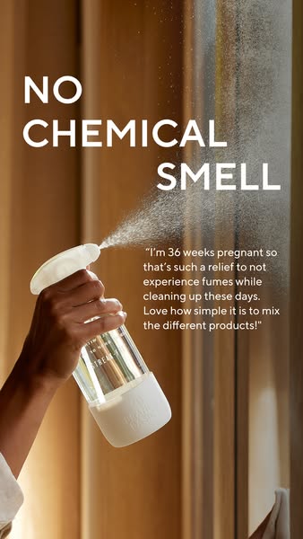 Hand spraying a glass Branch Basics bottle toward a sunlit window, headline No Chemical Smell and a pregnant customer's quote