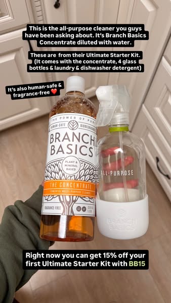 Hand holding Branch Basics Concentrate and an All-Purpose glass spray bottle, with creator captions and code BB15