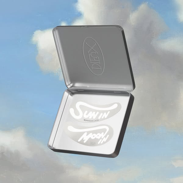 Open silver tin with two clear reusable eye masks printed Sun In and Moon In, floating on a painted blue sky