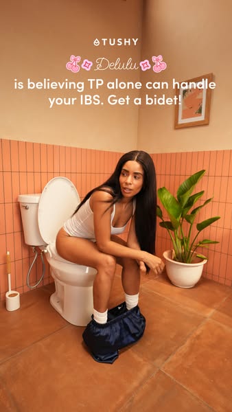 Woman on a toilet with a bidet in a terracotta bathroom under the headline Delulu is believing TP can handle your IBS