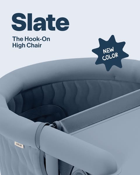 Close-up of the slate blue Lalo hook-on high chair with quilted wave fabric and a New Color starburst badge