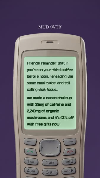 Retro beige mobile phone on purple background with a green screen text about too much coffee and a MUD WTR 43% off offer