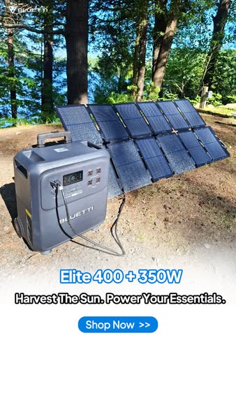 Bluetti Elite 400 power station connected to a large foldable solar panel on a forest campsite by a lake