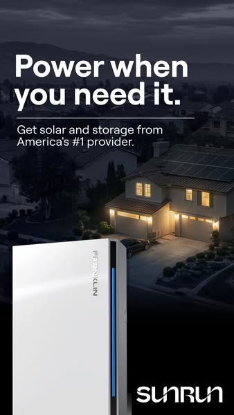 Two-storey house with solar panels lit at dusk in a dark neighbourhood, with a white Franklin home battery in the foreground