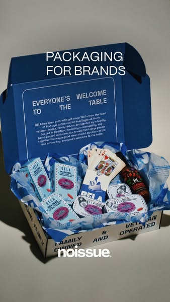 Noissue ad: an open blue BELA mailer box with an inside-lid brand story, blue tissue, tinned fish, playing cards and hot…
