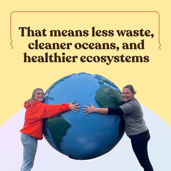 Two smiling women hugging a large blue globe sculpture on a yellow background with a headline about cleaner oceans