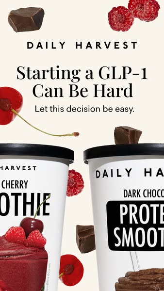 Two Daily Harvest smoothies, cherry and dark chocolate protein, with floating cherries, raspberries and chocolate on cream