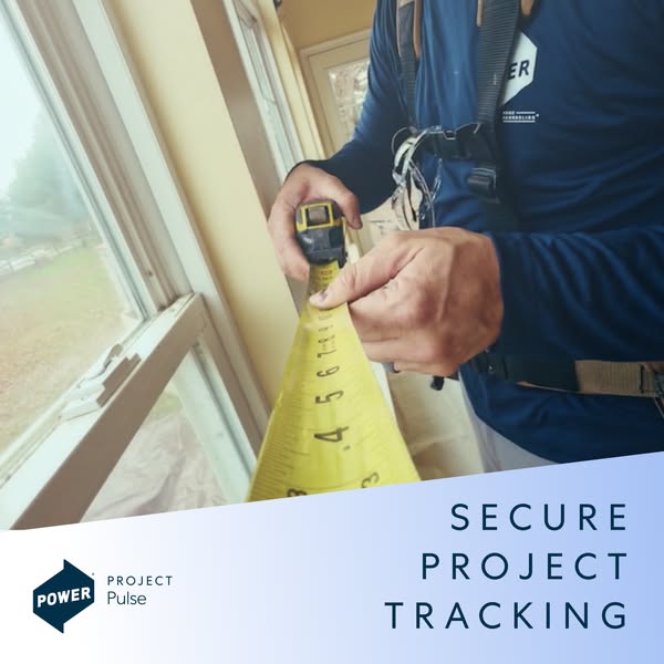 Power Home Remodeling installer in navy shirt measuring a window frame with a yellow tape measure