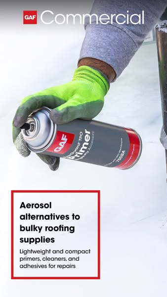 Hand in a green work glove holding a GAF aerosol TPO primer can over a white commercial roof membrane
