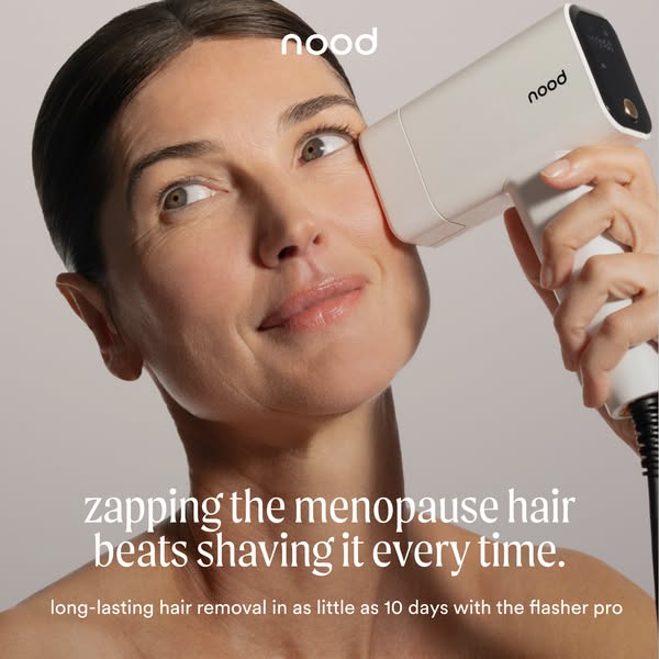 Mature woman with hair pulled back holding a white Nood IPL device to her cheek, smiling, with menopause hair headline below