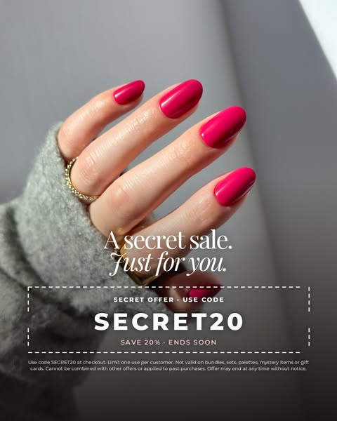 Hand in a grey knit sleeve with glossy hot pink press-on nails above a dashed coupon box with code SECRET20 for 20% off