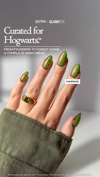 Hand with green leaf-vein Mandrake press-on nails, olive corduroy sleeve and gold ring, Curated for Hogwarts text