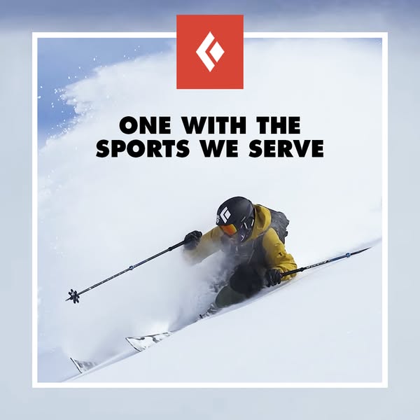 Skier in yellow jacket and black helmet carving through deep powder snow with Black Diamond logo and brand slogan