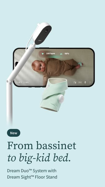 Owlet camera on a white floor stand above a phone showing a baby with 100 bpm and 98% readings, and a mint Dream Sock