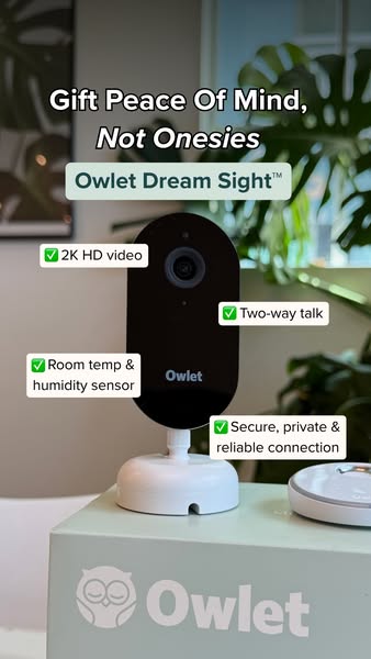 Owlet Dream Sight camera on a branded Owlet box with plants behind and four checkmarked feature labels around it