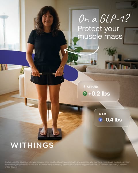 Smiling woman on a Withings smart scale with handle in a bright living room, cards: muscle +0.2 lbs, fat -0.4 lbs.