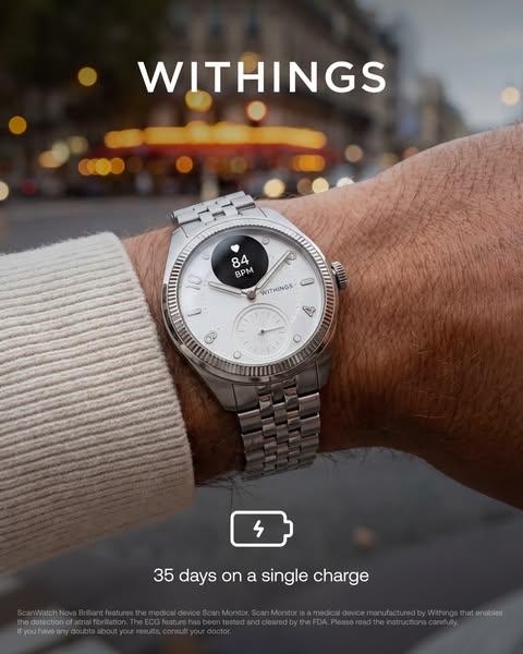 Steel Withings ScanWatch Nova Brilliant on a wrist, blurred Paris street at dusk, battery icon with 35-day claim.