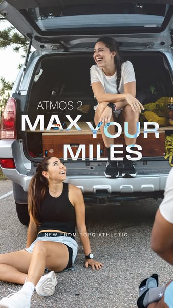 Two laughing women after a run, one sitting in an SUV trunk, one on the pavement, with text Atmos 2 Max Your Miles