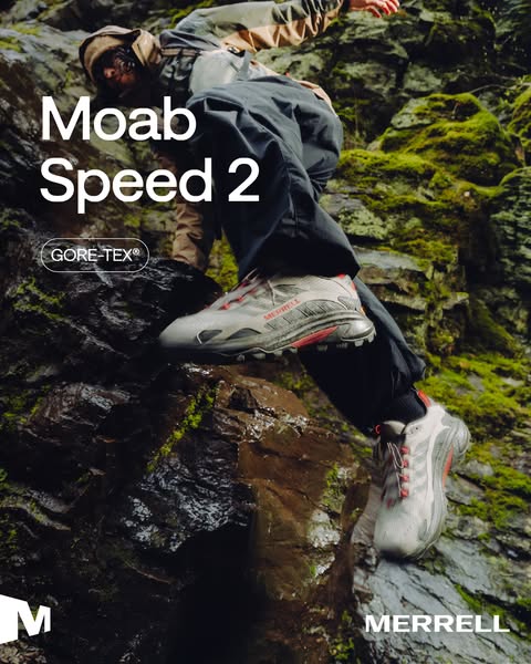Hiker climbs wet mossy rocks in light grey Merrell Moab Speed 2 GORE-TEX shoes with red accents