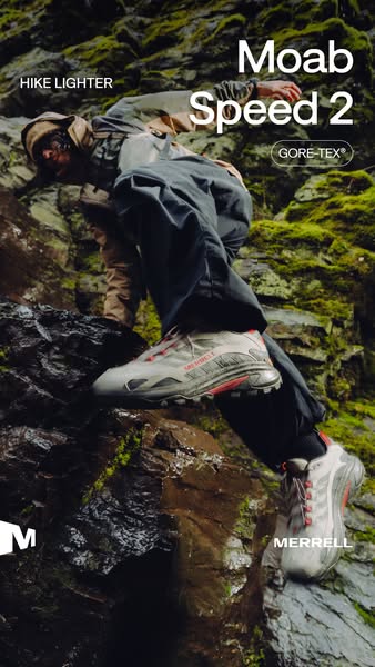 Hiker climbs wet green mossy rock in grey Merrell Moab Speed 2 GORE-TEX shoes with red accents, Hike Lighter text at top